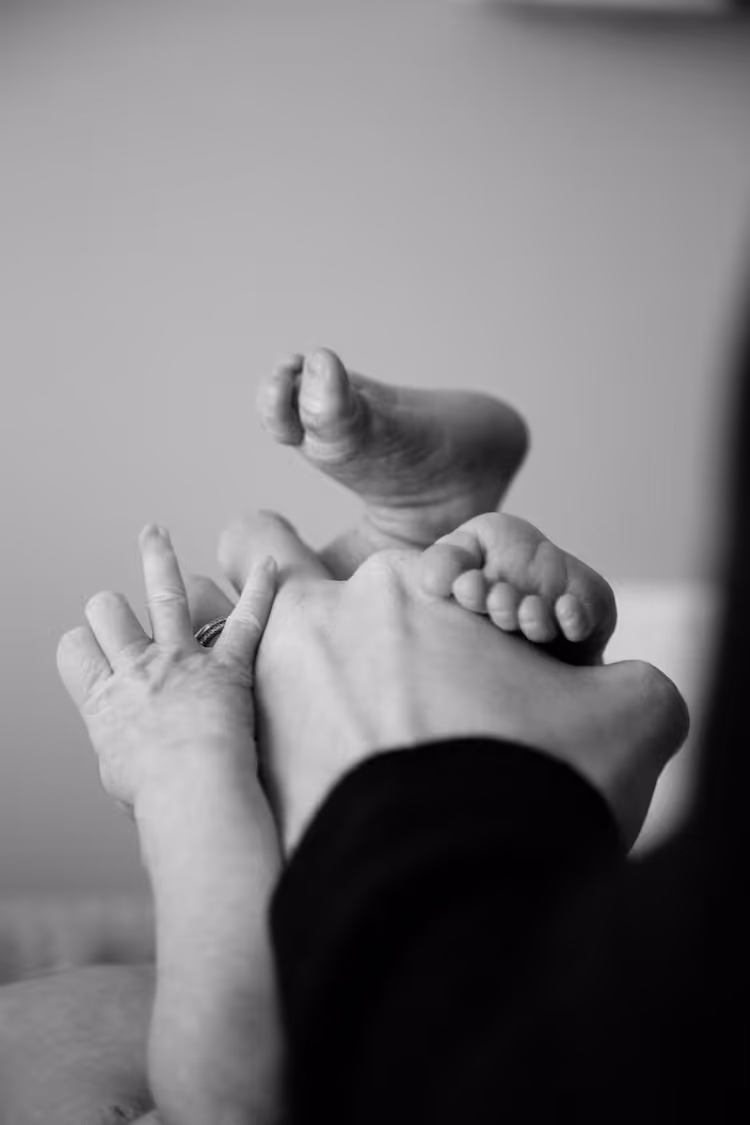 A parent holding their child's hands